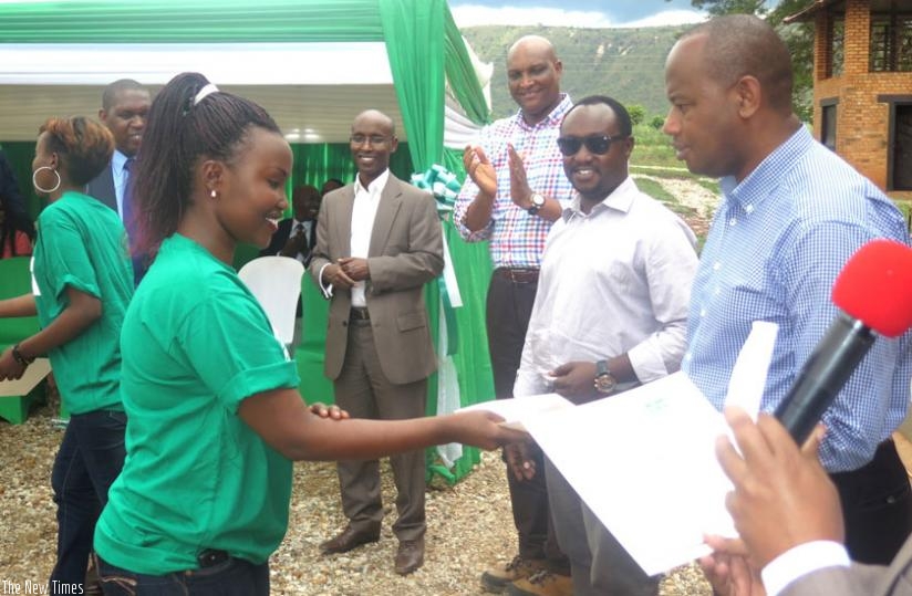 Minister Nsengiyumva gives certificate to one of the female trainees in Kayonza District on Wednesday. (Stephen Rwembeho)