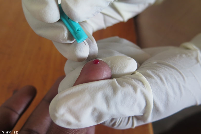 A medical worker extracts blood for an HIV test.