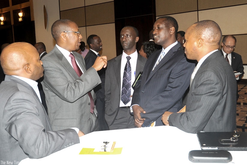 Rwangombwa (2nd L) chats with Bank of Kigali CEO, James Gatera (2nd R). Commercial banks have not been able to significantly reduce lending rates. (Timothy Kisambira)