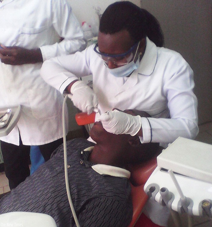 A dentist cleans a patient's teeth.