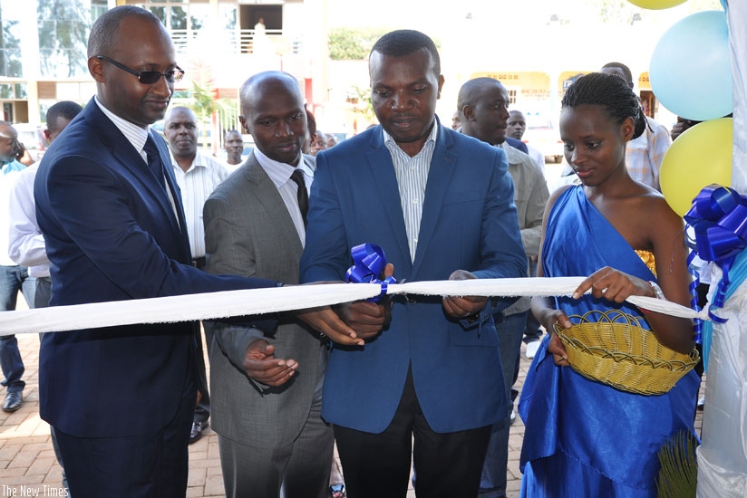 Bugunya (left) is joined by Rwamagana mayor Abdul Karim Uwizeyimana (second right) and other officials to cut the tape at the launch of Prime Insuranceu2019s 28th branch in the district. (Ivan Ngoboka)