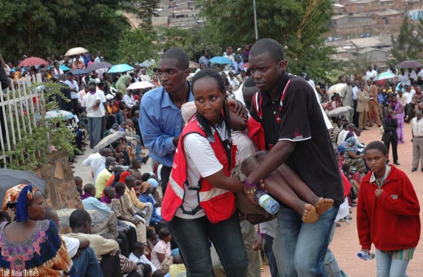 Redcross volunteers and residents of Bugesera carry away a traumatised patient during the 2008 commemoration. (File)