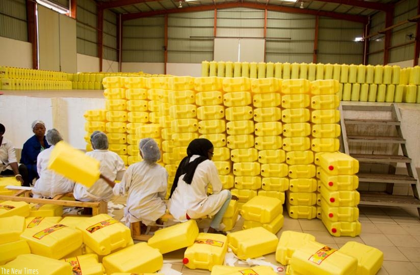 Workers at MMSL prepare cooking oil jerrycans for packaging. (Timothy Kisambira)