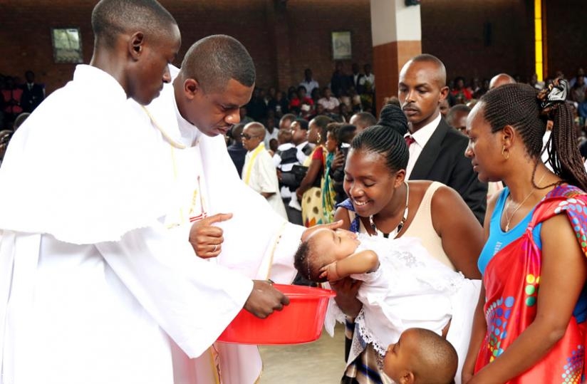 Fr. Jean Claude Muvandimwe baptises a baby during Holy Mass at St Michel Cathedral in Kigali on Easter Sunday. (John Mbanda)