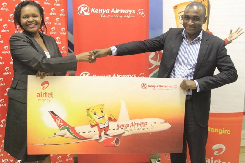 KQ's Kariuki and Airtel's Oware at the launch of the service. The product is expected ease booking of Kenya Airways airtickets. (Courtesy)
