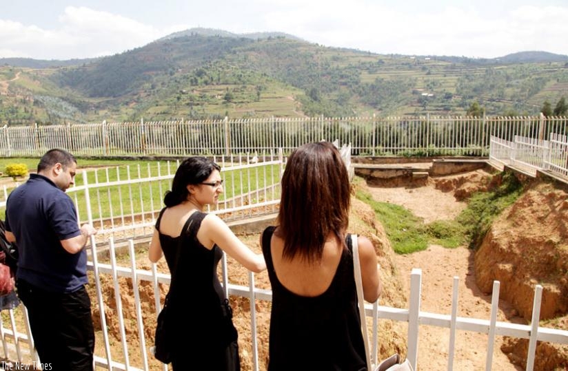 French youth look at a mass grave from which remains of hundreds of Genocide victims were exhumed for a descent burial. They were visiting Murambi memorial site last year. (John Mbanda)