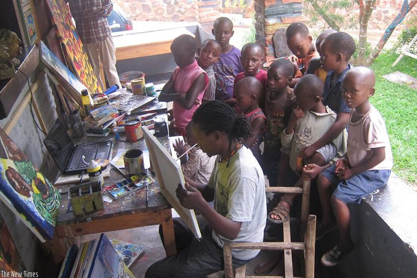 Bruce Niyonkuru paints as children watch. He has established Imizi Arts to help young girls learn how to paint. (Joseph Oindo)