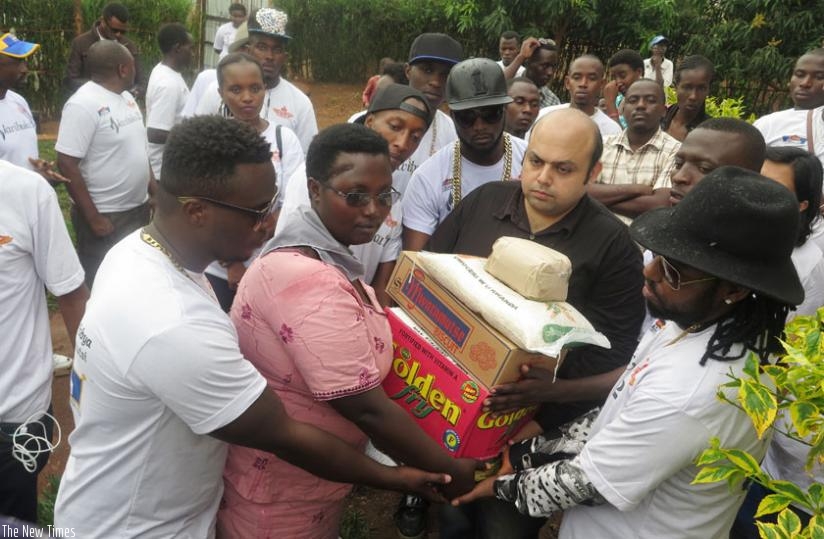 Vipul Kapul and the artistes hand over aid to Clodette Mukamamanzi.