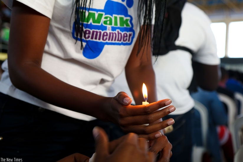 A youth lights a candle at Petit Stade-Remera in remembrance of the 1994 Genocide victims after the walk to remember last Sunday. (T.Kisambira)