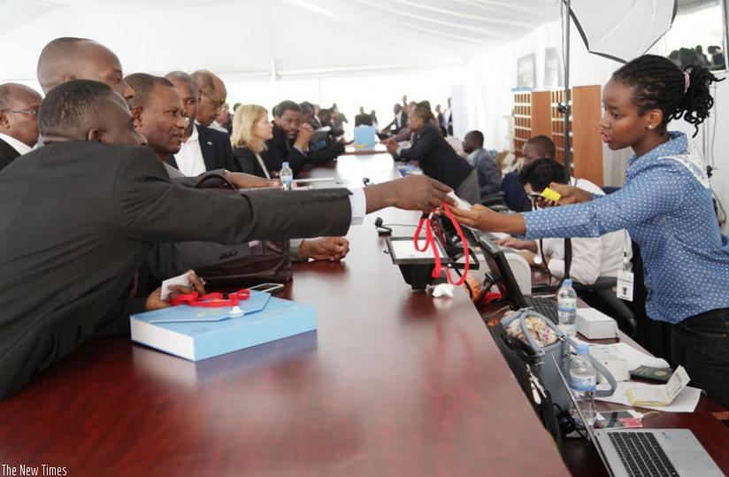 Delegates pick their accreditation cards before a series of AFDB meetings in Kigali last year. (File)