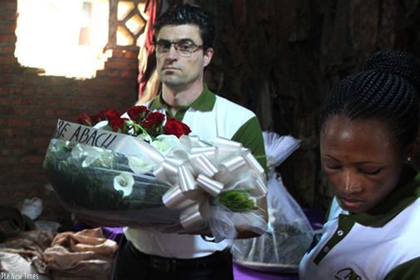 Frederic Auger, the Chairperson of NINGO holds wreath to lay on the coffins. (Jean Mugabo)