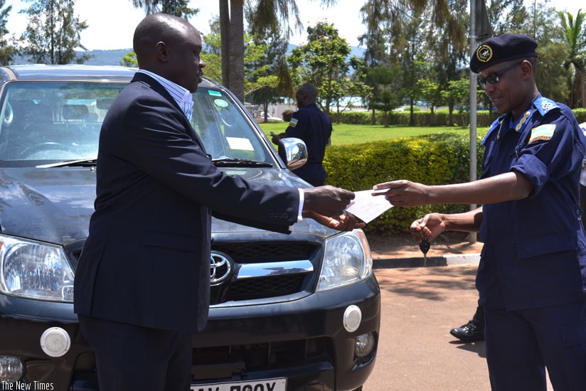 Commissioner for Interpol, ACP Tony Kuramba (R) hands over a stolen Toyota Hilux pickup truck recovered in Rwanda, to Patrick Lawot, the Liaison Officer at the Uganda High Commission in Rwanda. (File)