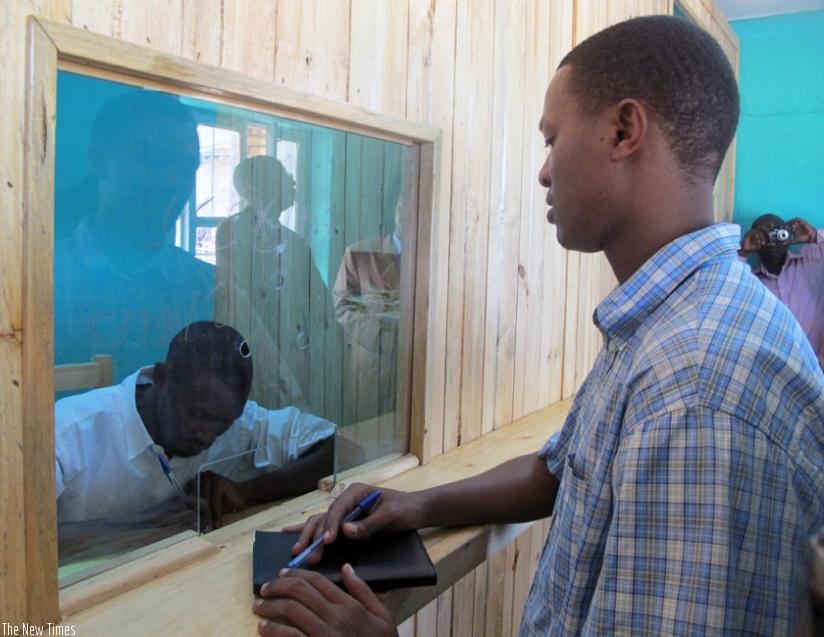 A client waits to receive money from a teller at a Credit Savings Cooperative (SACCO). (John Mbanda)