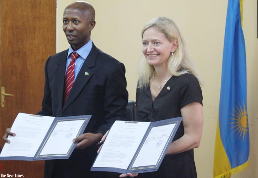 Harerimana of Rwanda (L) and Amb. Ms. Barks-Ruggles display the documents after the signing on Wednesday in Kigali. (Courtesy)