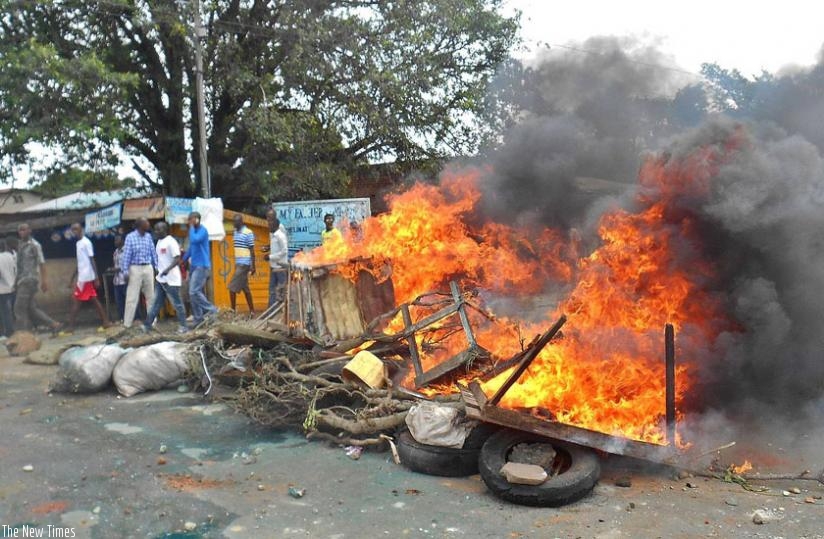 Demonstrators walk next to a burning barricade during clashes with police in Cibitoke, north-western Burundi, on Saturday, as protests escalated over a bid by the president to seek a third term. (Net photo)