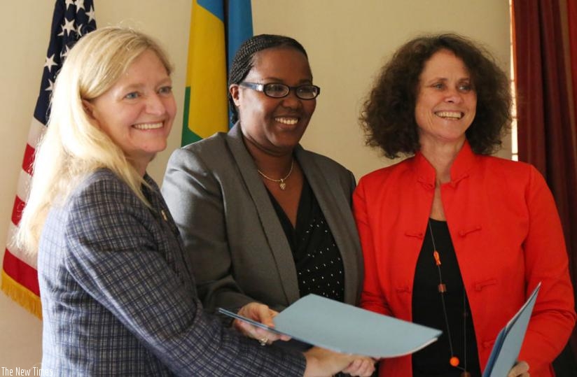 L-R; Amb.Barks-Ruggles, Minister Mukeshimana and Carolyn Turk  exchange documents after signing yesterday. (John Mbanda)