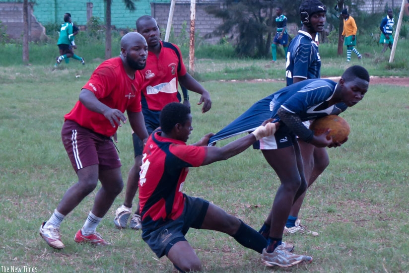 Muhanga's center Laurien Hakizimana tries to stop 1000 Hills' flyhalf Carlos Isimbi during the second half. rn(S. Kalimba)