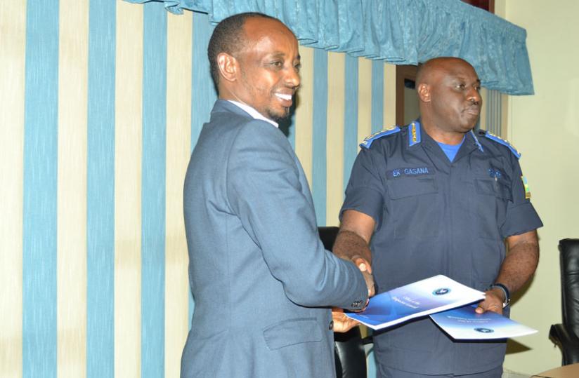 IGP Gasana and Claver Mugabo the PSF's vice chairman exchange documents after the signing yesterday. (Courtesy)