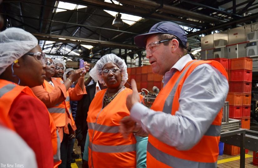 Minister Uwizeye (left) and Minister Binagwaho listen to a Bralirwa official during the factory tour. (Jean du2019Amour Mbonyinshuti)