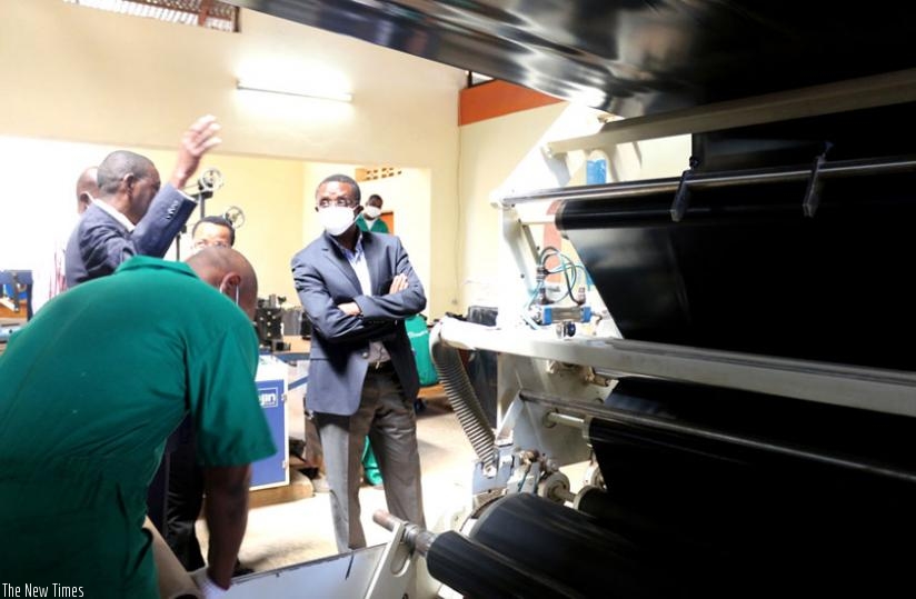 Habamungu (L) explains to Dr Biruta how sheeting products are made from recycling plastics. (Michel Nkurunziza)