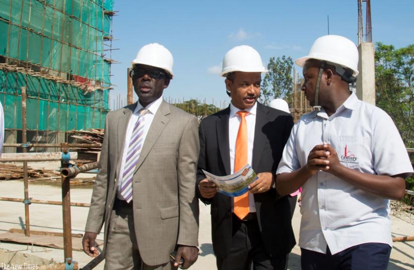 Karera (L), Teame (C) and Charles Haba, director of Century Real Estate, the company charged with rentals at Kigali Heights, tour the facility yesterday . (Timothy Kisambira)