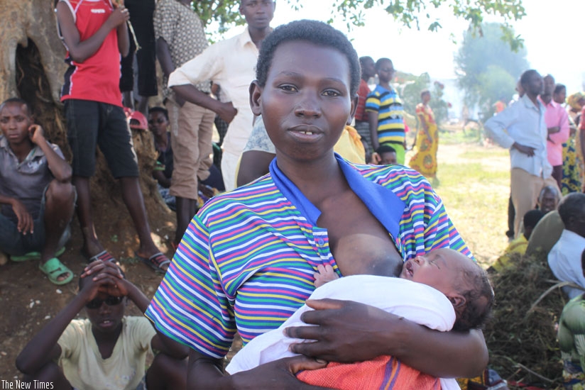 Baby Mahama breast feeds. At the background are some unaccompanied children aged 17 and below who fled Burundi without their parents.  (Kenneth Agutamba)