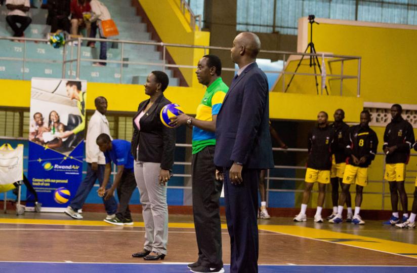 Senate President Bernard Makuza prepares to strike the Ball to officially open the ceremony. On his left is Sports Minister Julienne Uwacu while the Volleyball Federation Chairman Gustave Nkurunziza is on the right.