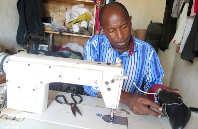 Simugomwa assesses a shoe design at his tannery in Kibeho. (Emmanuel  Ntirenganya)