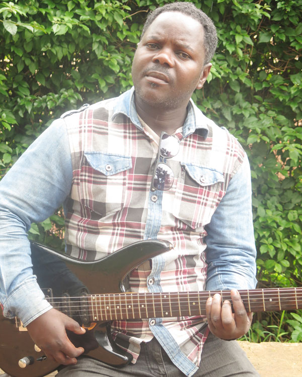 Singer and guitarist Dodos Rukema plays a guitar outside his house in Karuruma, Kigali. (A. Agaba)
