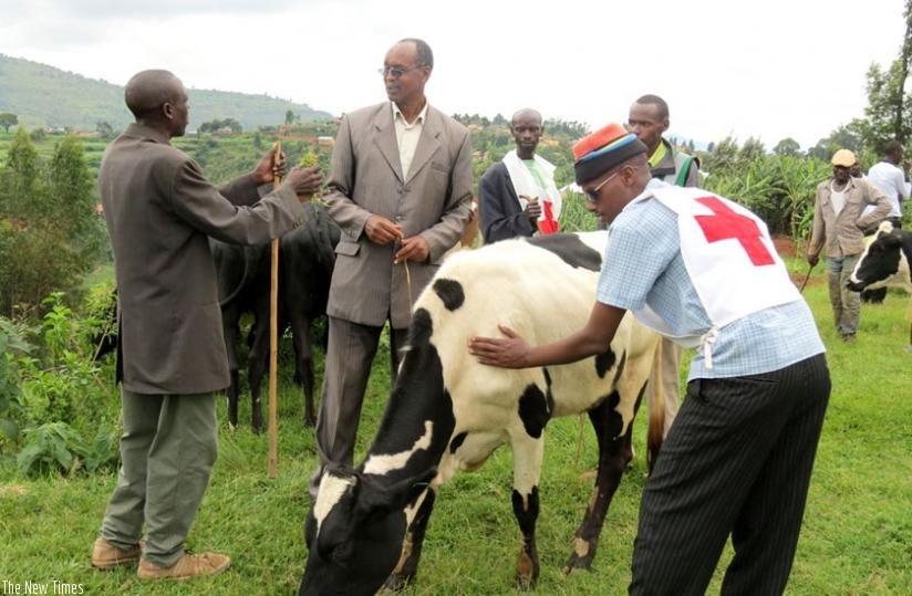 Nzigiye (C) talks to a local leader after delivering a cow. (Lydia Atieno)