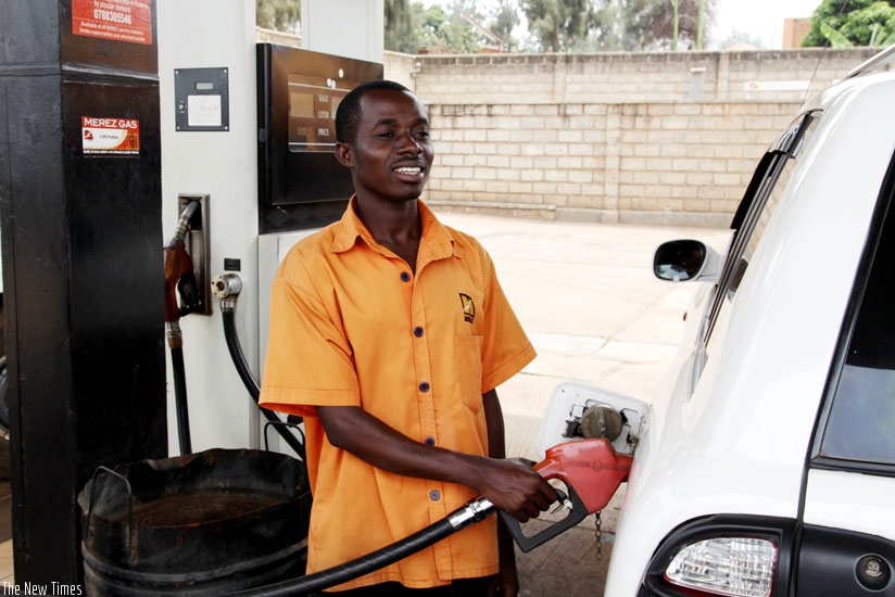 A pump attendant refills a car. Fuel pump prices are rising again after plummeting for months. (File)
