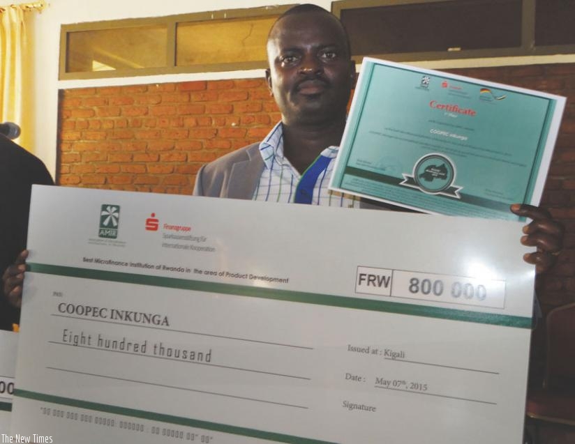 Nsengimana displays a dummy cheque for COOPEC Inkunga Sacco worth Rwf0.8m. The Sacco won in the ICT innovation category. (Peterson Tumwebaze)
