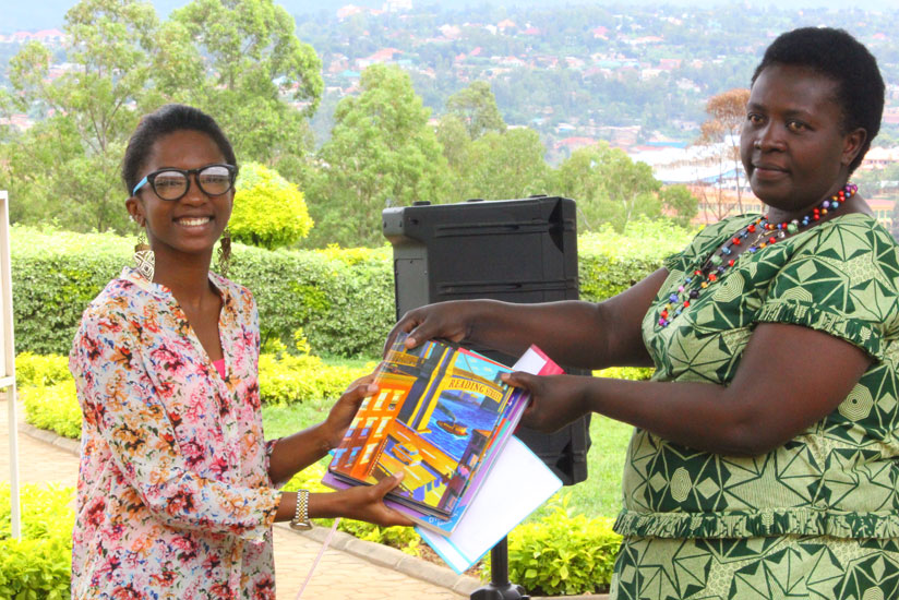Dominique Alonga  hands over the books to Alodie Nyirandegeya