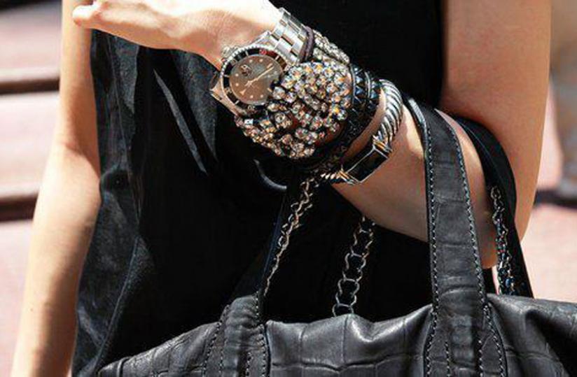 A trendy watch, wrist bands and bag.