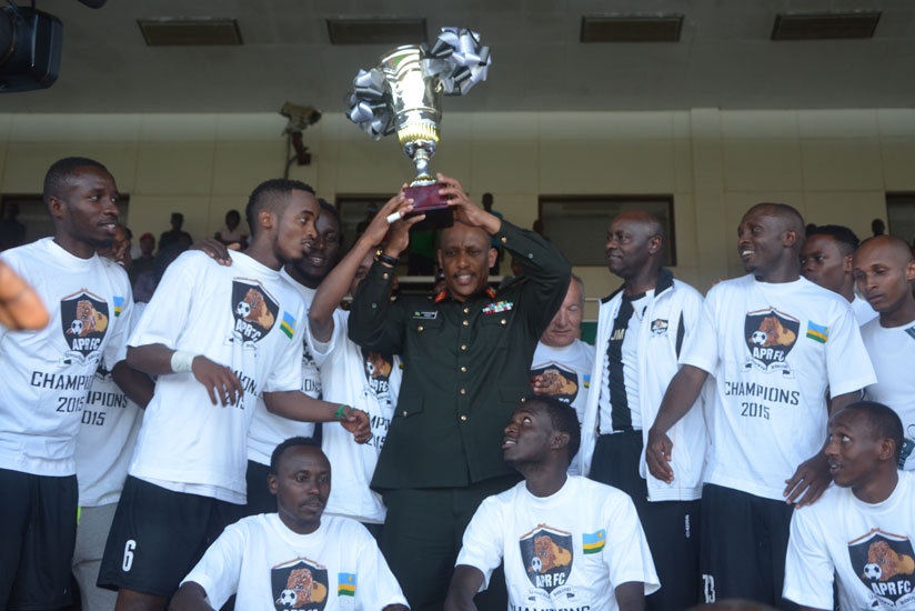 RDF Chief of Defence Staff Gen. Patrick Nyamvumba hoists the trophy with APR players. (Sam Ngendahimana)rn