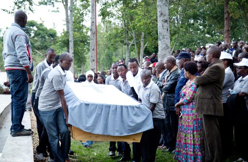 Pallbearers carry a casket containing the  remains of Genocide victims during the reburial at Kinazi memorial site. (Michel Nkurunziza)