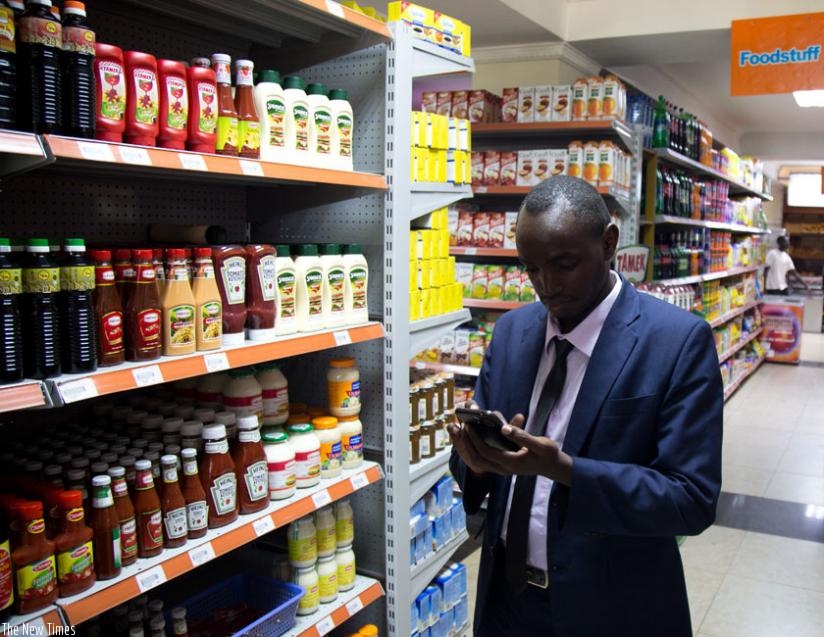 A shoperat Simba super market surfs  using a 4GLTE. (Timothy Kisambira)