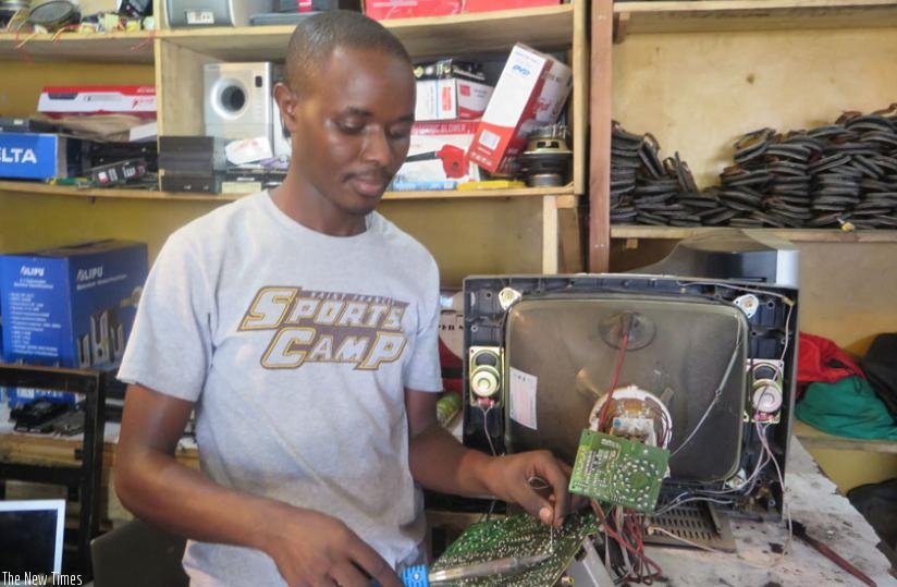A technician repairs a TV set. Most businesses are not aware that they can use their good credit history to get lower loan rates. (Jean Nepo Ndikumana)