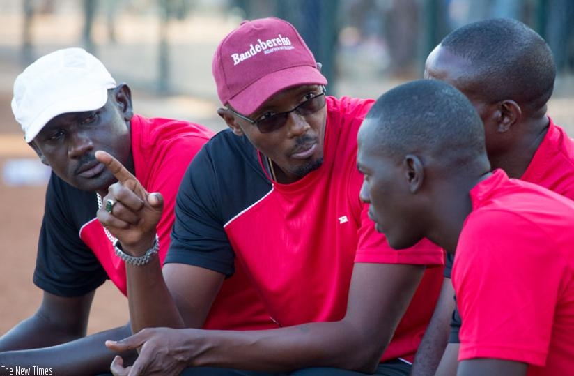 AS Kigali coach Eric Nshimiyimana (center) shares a point with his coaching staff during a league match against Police FC earlier this season. (Timothy Kisambira)