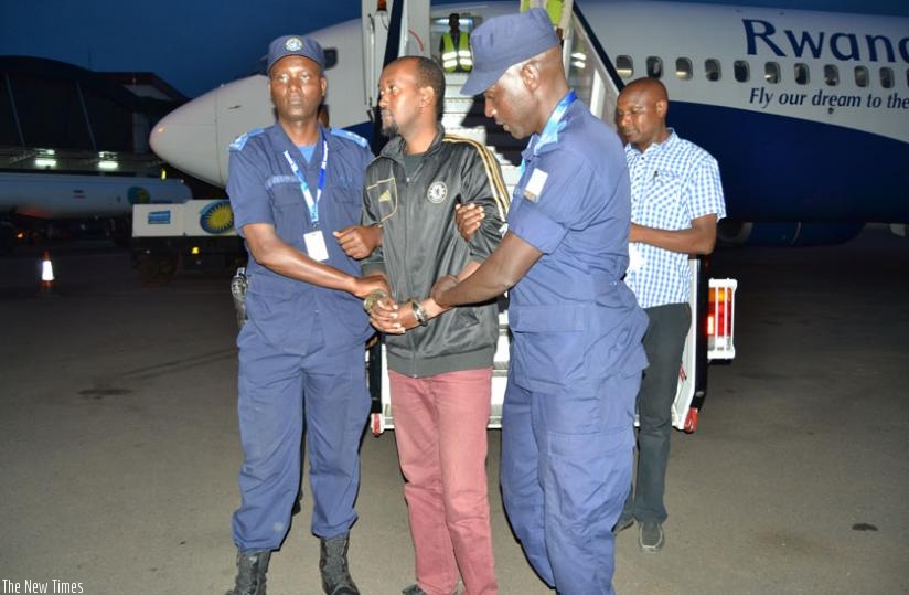 Javier Desire Ndisabiye is received by RNP officers at Kigali International Airport. (Courtesy)