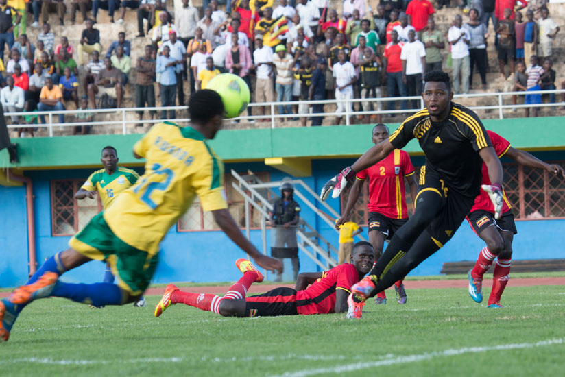Dominique Savio Nshuti (L) heads home Rwanda's sole goal as Ugandan goalkeeper Salim Jamal looks on. (Timothy Kisambira)