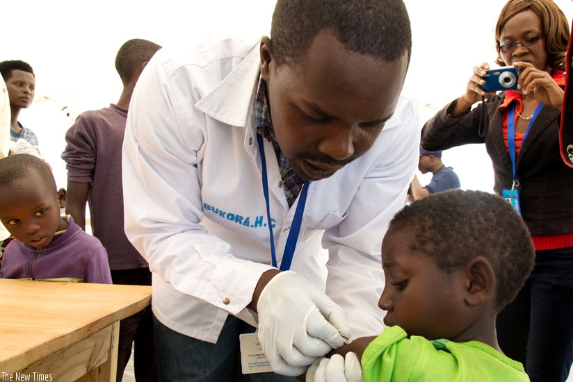 A health worker immunises a Burundian child at Mahama Refugee Camp on Saturday. (Timothy Kisambira)