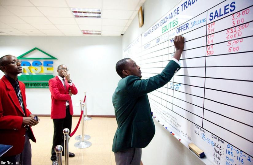A stock broker transacts business. Minister Gatete has called on the African Development Bank to work out a robust plan of developing stock markets in Africa. (Timothy Kisambira)