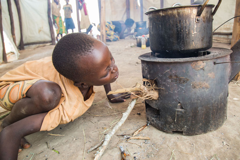 A Burudian child prepares a meal at Mahama refugee camp. ( All photos by Timothy Kisambira)