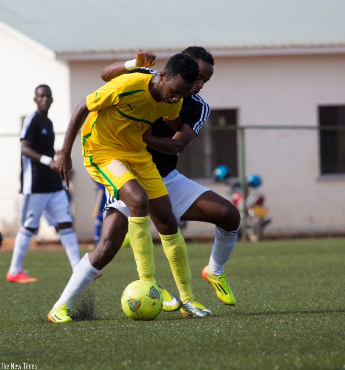 AS Kigali's Justin Mico (in yellow) fights for the ball with Yannick Mukunzi of APR in a league encounter in March. (File)