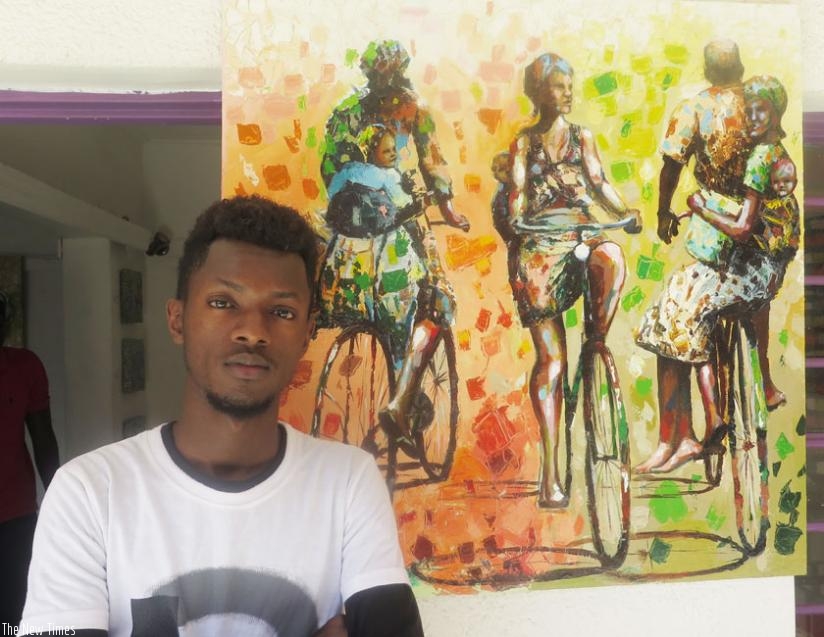 Jackson Manzi poses next to his 'The journey goes on' artwork. (Arnold Agaba)