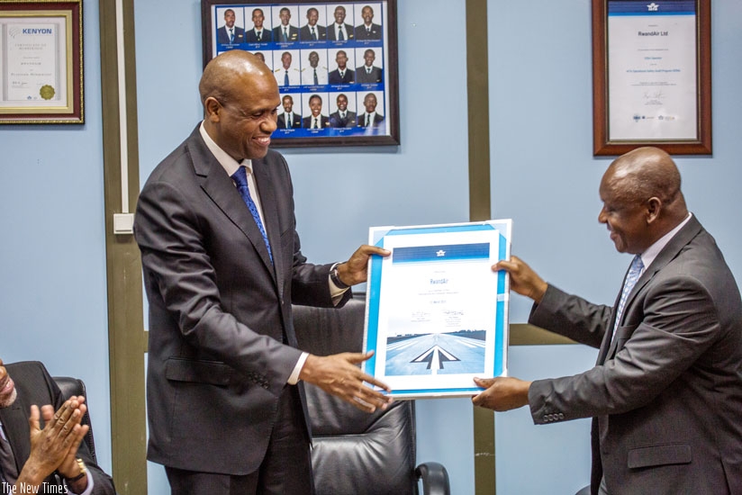RwandAir CEO John Mirenge (L) receives a certificate from Raphael Kuuchi, the vice president of International Air Transport Association at Kigali International Airport on Tuesday. (File)