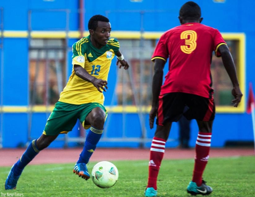 Dominique Savio Nshuti  (L) attempts to go past a Ugandan defender during the Olympic qualifier first leg in Kigali recently. (T. Kisambira)