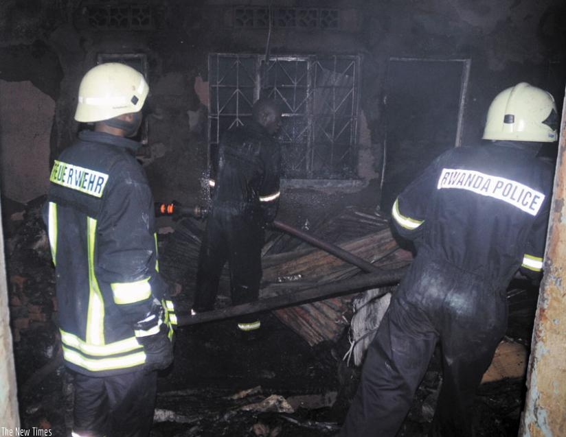 Policemen put out fire that engulfed stores in Kigali last year. Insurance reduces burden of such fires. (File)