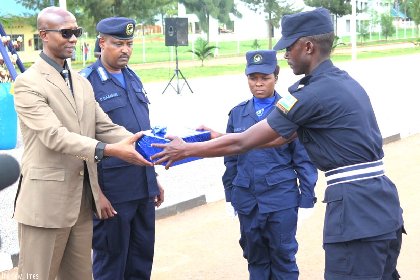 Internal Security minister Fazil Harerimana rewards the top performers at the Police graduation at Gishari Police Training School yesterday. (Stephen Rwembeho)